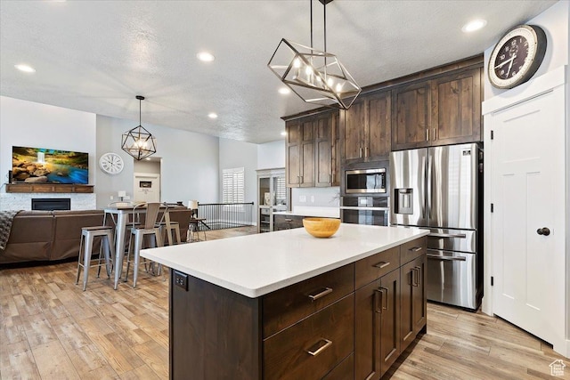 3851 N 425 E, North Ogden, UT 84414 - kitchen featuring appliances with stainless steel finishes, a center island, light hardwood / wood-style floors, and pendant lighting