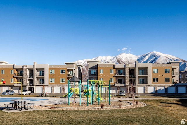 community jungle gym featuring a mountain view and a yard