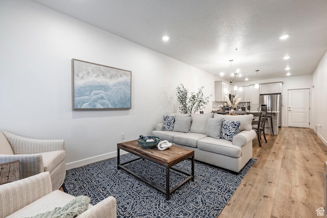 living area featuring light wood-type flooring, baseboards, and recessed lighting