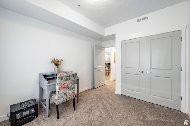 carpeted office space featuring visible vents and baseboards