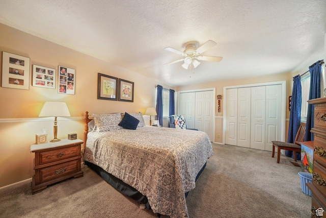 carpeted bedroom featuring ceiling fan, multiple closets, baseboards, and multiple windows