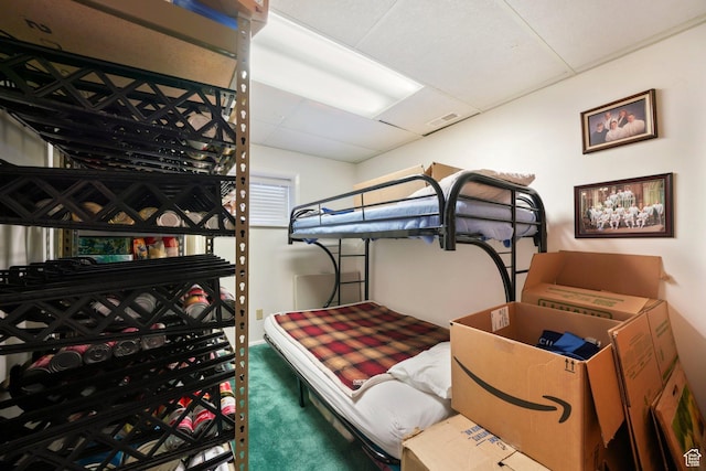 bedroom featuring carpet flooring and a drop ceiling