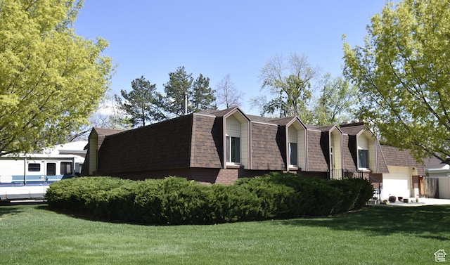 view of home's exterior featuring a lawn, a gambrel roof, mansard roof, and roof with shingles