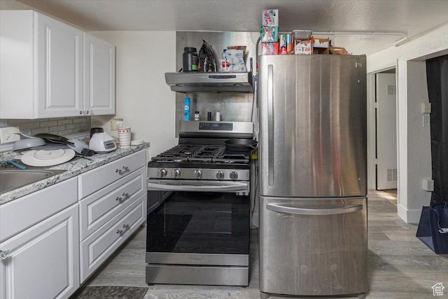 138 Crockett Ave, Logan, UT 84321 - kitchen featuring sink, white cabinetry, light stone counters, appliances with stainless steel finishes, and dark hardwood / wood-style floors