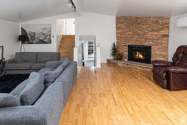 138 Crockett Ave, Logan, UT 84321 - living room with lofted ceiling, hardwood / wood-style floors, a stone fireplace, and a wall unit AC