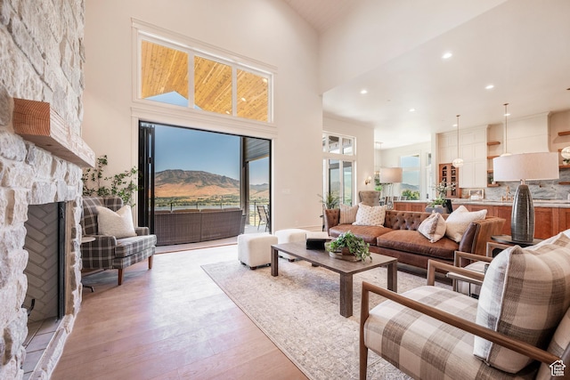 6736 E Via Cortina, Huntsville, UT 84317 - living room with a mountain view, a fireplace, high vaulted ceiling, and light hardwood / wood-style floors