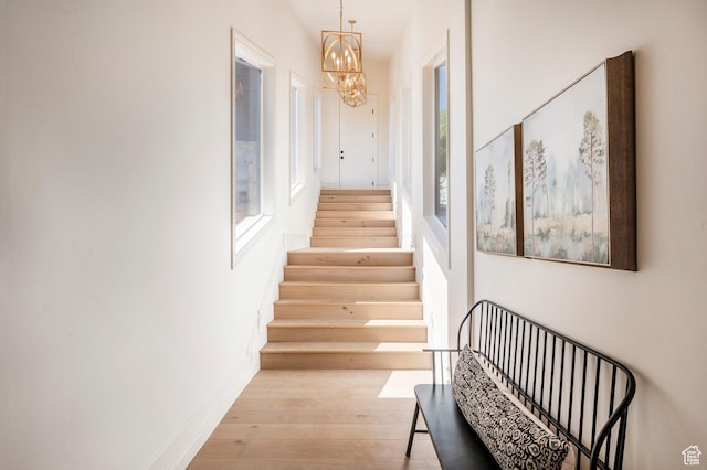 6736 E Via Cortina, Huntsville, UT 84317 - stairway featuring hardwood / wood-style floors, a healthy amount of sunlight, and an inviting chandelier