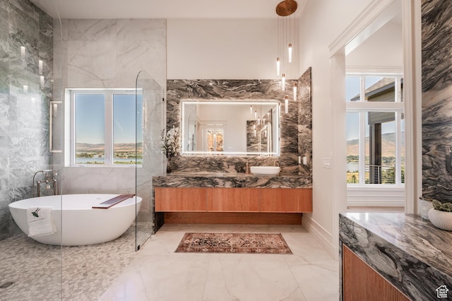 6736 E Via Cortina, Huntsville, UT 84317 - bathroom featuring vanity, a healthy amount of sunlight, a tub to relax in, and tile walls