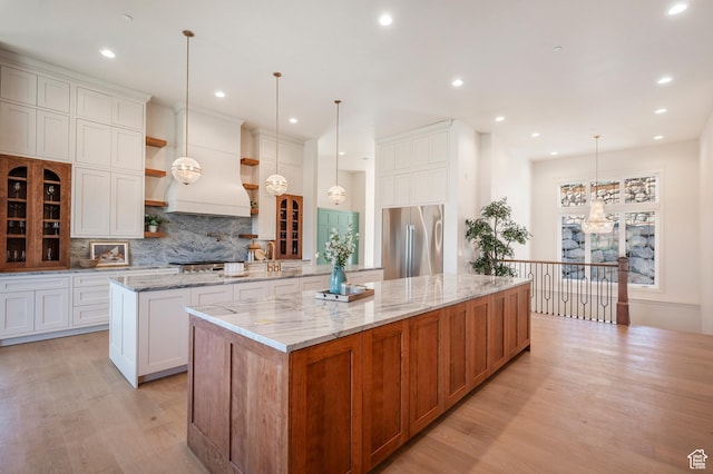 6736 E Via Cortina, Huntsville, UT 84317 - kitchen with premium range hood, high end fridge, pendant lighting, white cabinetry, and a large island