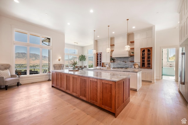 6736 E Via Cortina, Huntsville, UT 84317 - kitchen featuring pendant lighting, a mountain view, white cabinets, a large island, and light stone counters