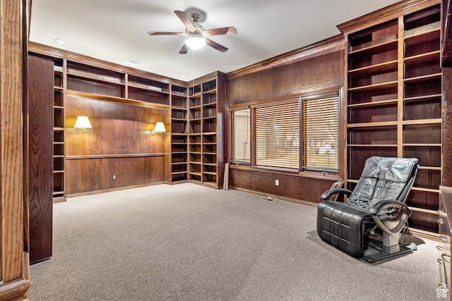 unfurnished room featuring carpet flooring, ceiling fan, and wooden walls
