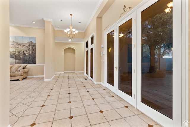 corridor featuring a chandelier, ornamental molding, light tile patterned floors, and french doors