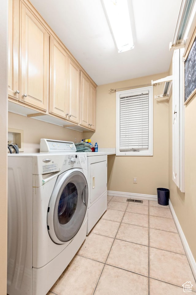 washroom featuring cabinets, independent washer and dryer, and light tile patterned flooring