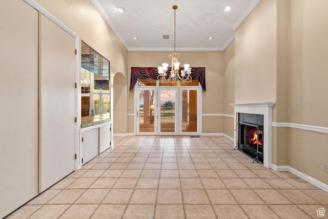unfurnished dining area with light tile patterned floors, ornamental molding, a tile fireplace, and a chandelier