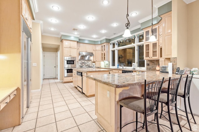 kitchen with kitchen peninsula, tasteful backsplash, light stone counters, hanging light fixtures, and a breakfast bar area