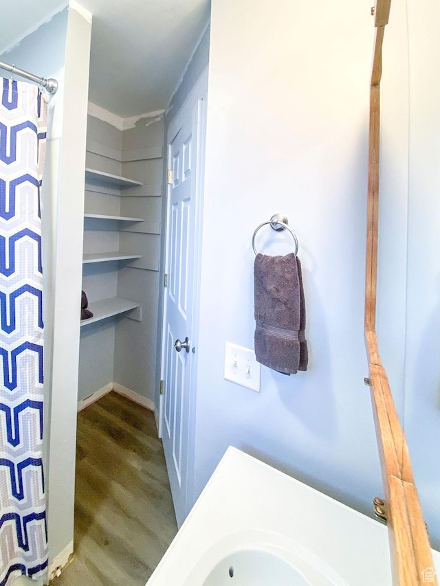 bathroom featuring hardwood / wood-style flooring and a shower with shower curtain