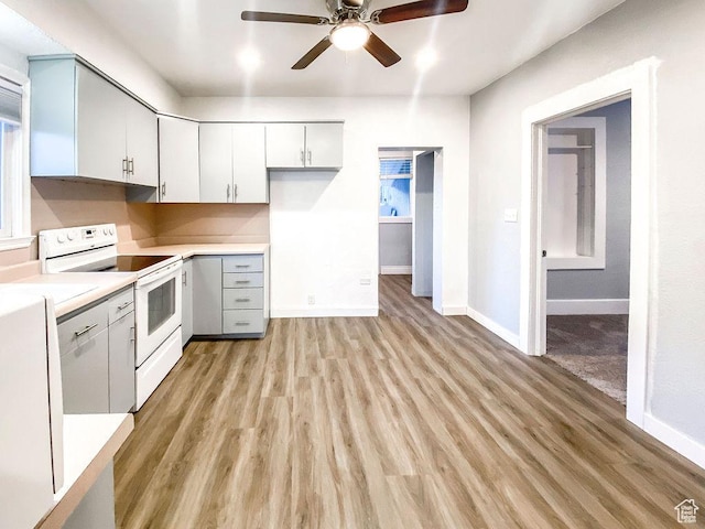 kitchen with gray cabinetry, ceiling fan, light hardwood / wood-style flooring, and electric range