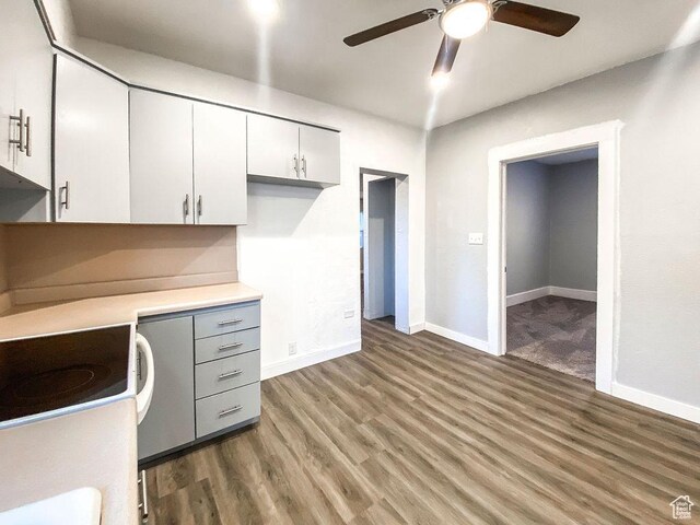 unfurnished office featuring dark wood-type flooring and ceiling fan