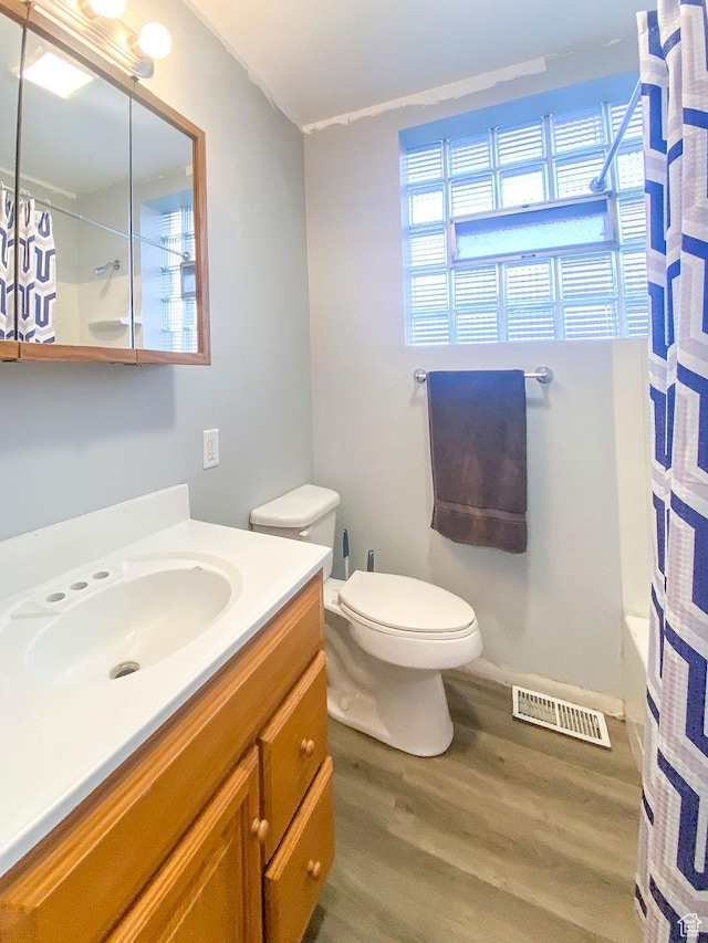 full bathroom featuring shower / bath combination with curtain, vanity, toilet, and hardwood / wood-style floors