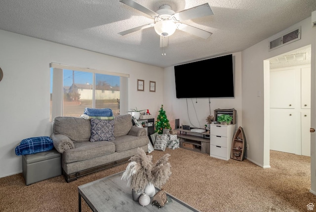 carpeted living room featuring ceiling fan and a textured ceiling