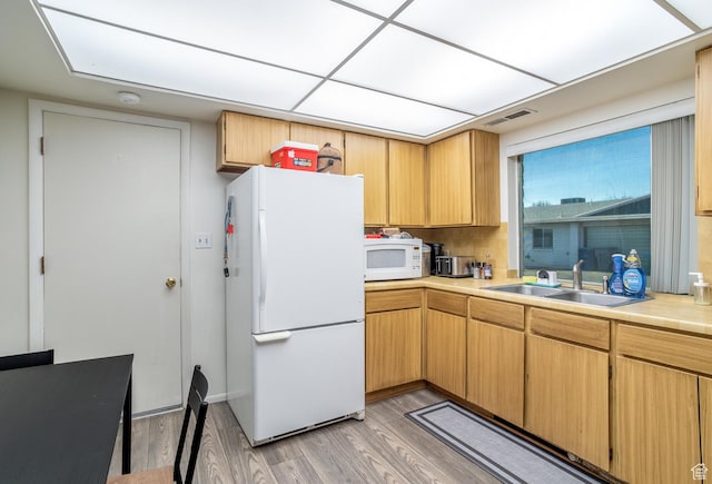 kitchen featuring light wood-type flooring, white appliances, and sink
