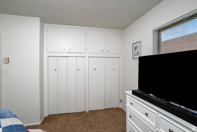 bedroom with a closet, light colored carpet, and a textured ceiling