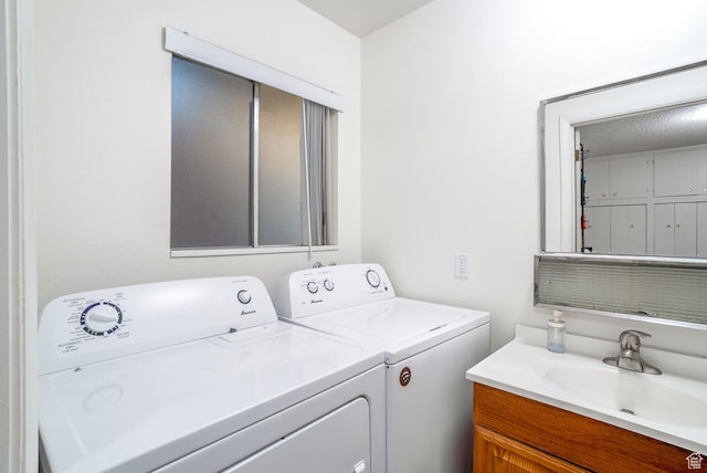 laundry area with a textured ceiling, washer and dryer, and sink