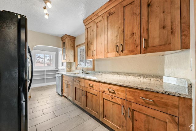 845 Binford St, Ogden, UT 84401 - kitchen featuring light stone countertops, black fridge, stainless steel dishwasher, a textured ceiling, and sink