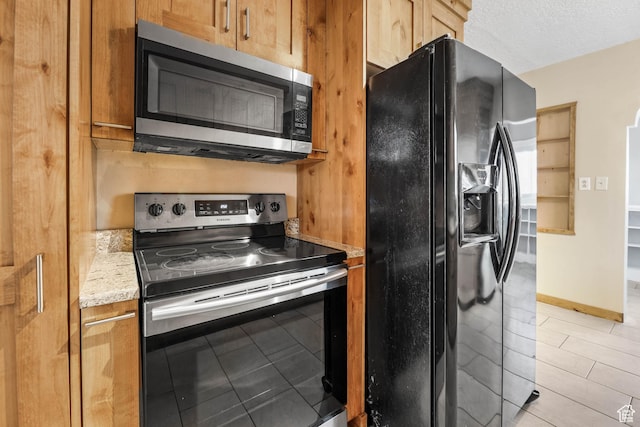 845 Binford St, Ogden, UT 84401 - kitchen featuring light tile patterned flooring, light stone countertops, a textured ceiling, and appliances with stainless steel finishes