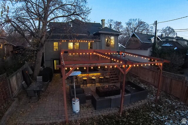 121 T St, Salt Lake City, UT 84103 - rear view of property with a fenced backyard, a wooden deck, a fire pit, and a patio