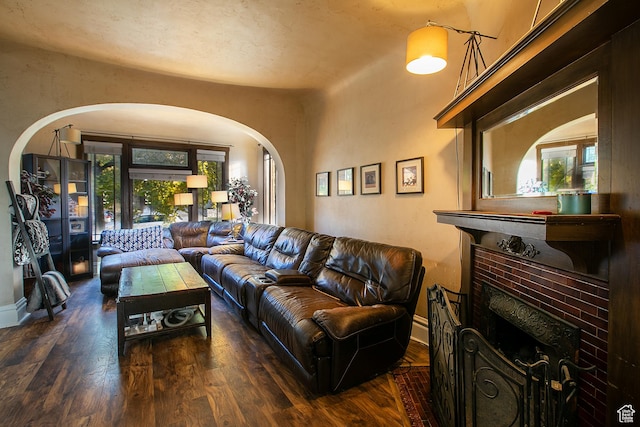 121 T St, Salt Lake City, UT 84103 - living room with arched walkways, wood finished floors, a brick fireplace, and baseboards