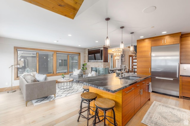 45 King Rd, Park City, UT 84060 - kitchen featuring modern cabinets, brown cabinetry, stainless steel built in refrigerator, dark countertops, and a breakfast bar area