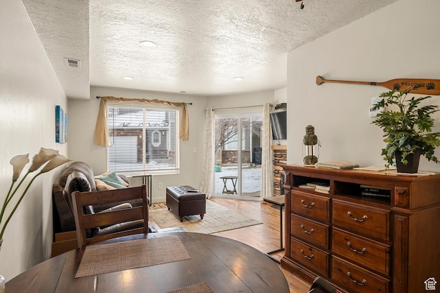 sitting room with a textured ceiling and light wood-style floors