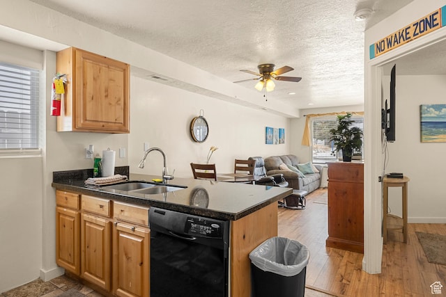 kitchen featuring dishwasher, ceiling fan, a sink, a peninsula, and plenty of natural light