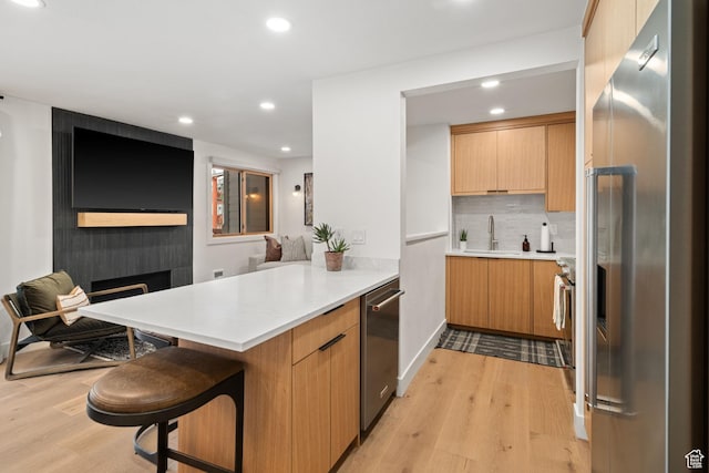 401 Silver King Dr, Park City, UT 84060 - kitchen with a breakfast bar area, kitchen peninsula, light wood-type flooring, and appliances with stainless steel finishes