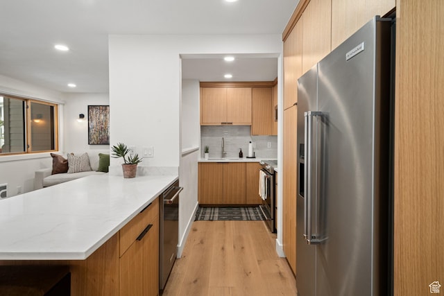 401 Silver King Dr, Park City, UT 84060 - kitchen featuring sink, light hardwood / wood-style flooring, decorative backsplash, appliances with stainless steel finishes, and kitchen peninsula