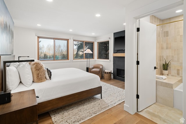 401 Silver King Dr, Park City, UT 84060 - bedroom featuring a large fireplace, recessed lighting, light wood-style flooring, and ensuite bathroom