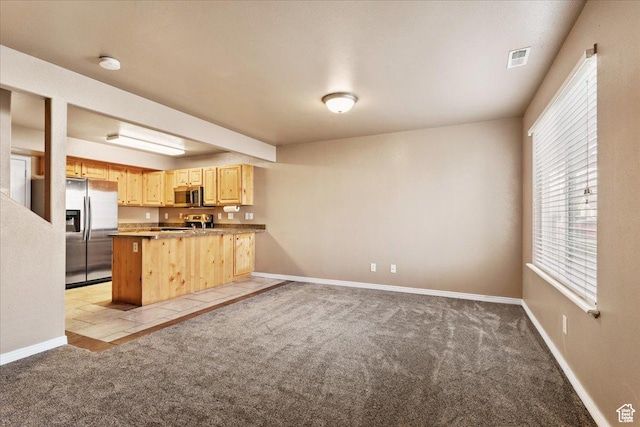 419 E 475 N, Ogden, UT 84404 - kitchen featuring kitchen peninsula, appliances with stainless steel finishes, light carpet, light brown cabinets, and a breakfast bar area
