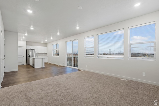 3474 S 3100 W Unit 146, West Haven, UT 84401 - unfurnished living room with dark colored carpet, recessed lighting, baseboards, visible vents, and dark wood-style floors