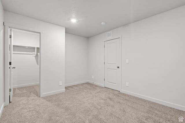 3474 S 3100 W Unit 146, West Haven, UT 84401 - unfurnished bedroom with a walk in closet, carpet, baseboards, visible vents, and a closet