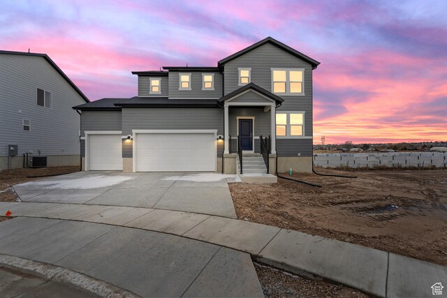 view of front property featuring a garage and central AC unit