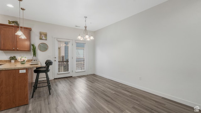 1026 N Shepard Creek Pkwy Unit 4, Farmington, UT 84025 - kitchen featuring hardwood / wood-style floors, a breakfast bar, hanging light fixtures, and an inviting chandelier