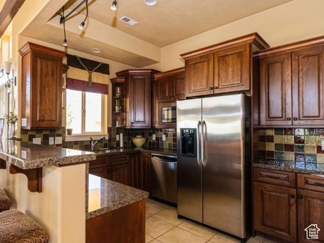 1026 N Shepard Creek Pkwy Unit 4, Farmington, UT 84025 - kitchen with decorative backsplash, dark stone countertops, light tile patterned floors, and appliances with stainless steel finishes