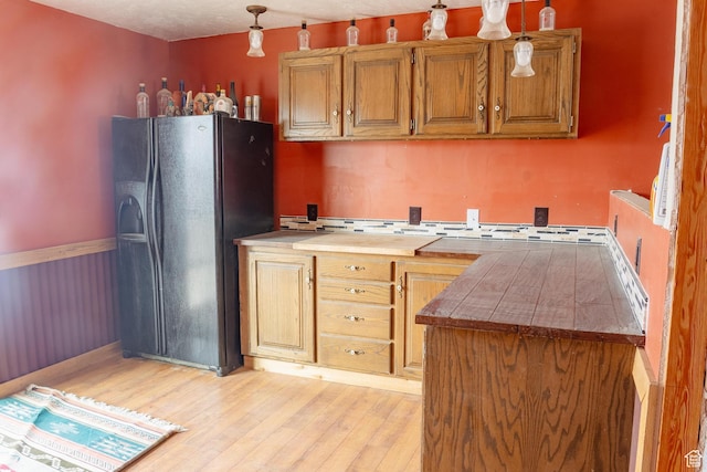 332 S Allens Ranch Rd, Fairfield, UT 84013 - kitchen featuring black fridge, light wood-style flooring, decorative light fixtures, brown cabinetry, and light countertops
