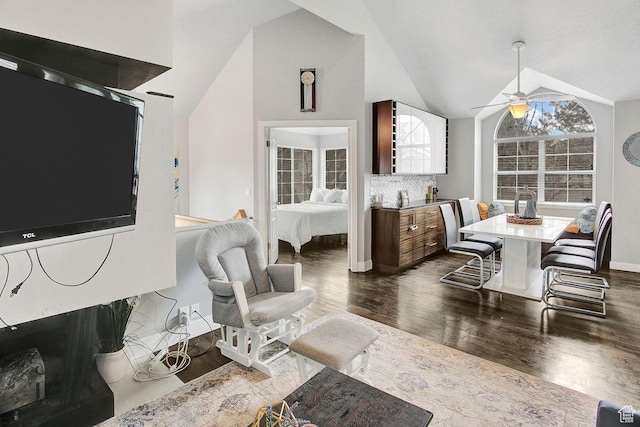 living room with high vaulted ceiling, ceiling fan, and dark wood-type flooring
