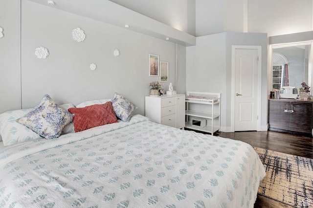 bedroom featuring dark hardwood / wood-style flooring and a high ceiling