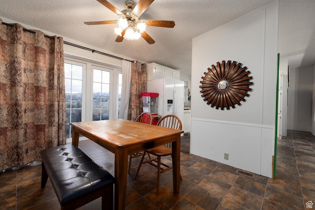 dining space with ceiling fan and a textured ceiling