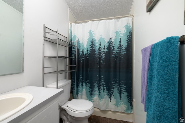 full bathroom featuring tile patterned floors, vanity, a textured ceiling, and toilet