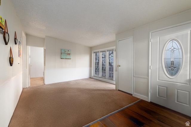 entryway with dark hardwood / wood-style flooring and a textured ceiling