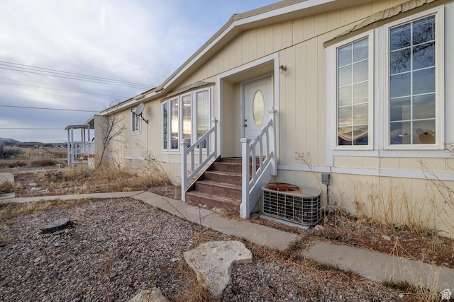 view of exterior entry featuring central air condition unit